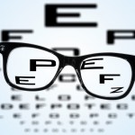 eyeglasses over a blurry eye chart